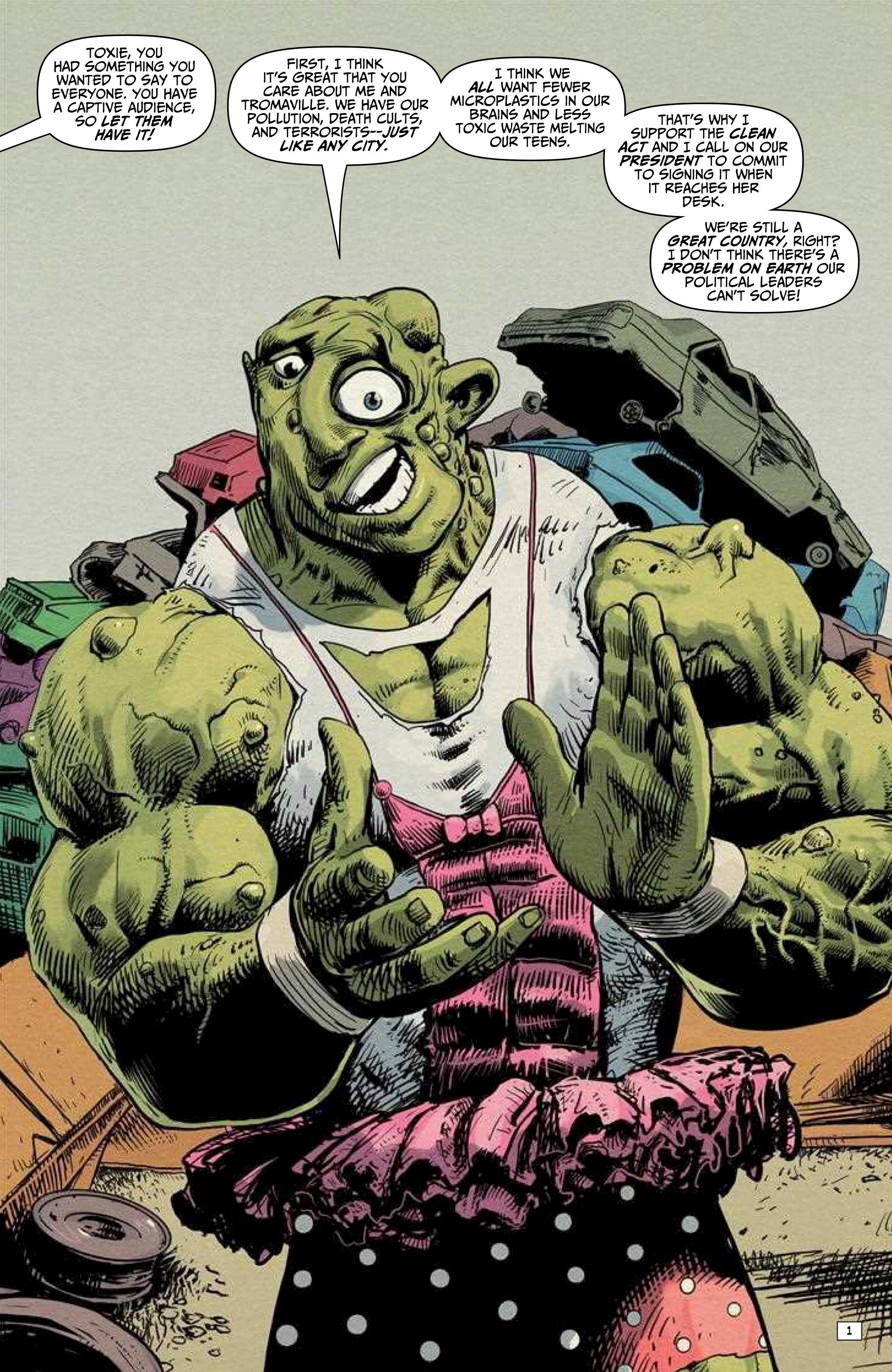 A large, muscular green character in a pink tutu and polka-dot skirt stands among junked cars, speaking and gesturing with both hands. Speech bubbles indicate dialogue.