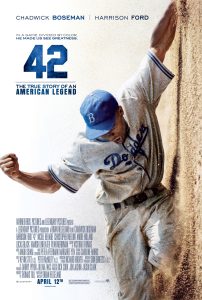 A baseball player in a Dodgers uniform slides into base against a dirt wall. The poster text includes the title "42" and credits for the film about Jackie Robinson.