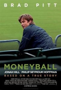 Movie poster for "Moneyball" shows a man seated in a stadium, looking over his shoulder. The film stars Brad Pitt, Jonah Hill, and Philip Seymour Hoffman, and is based on a true story.