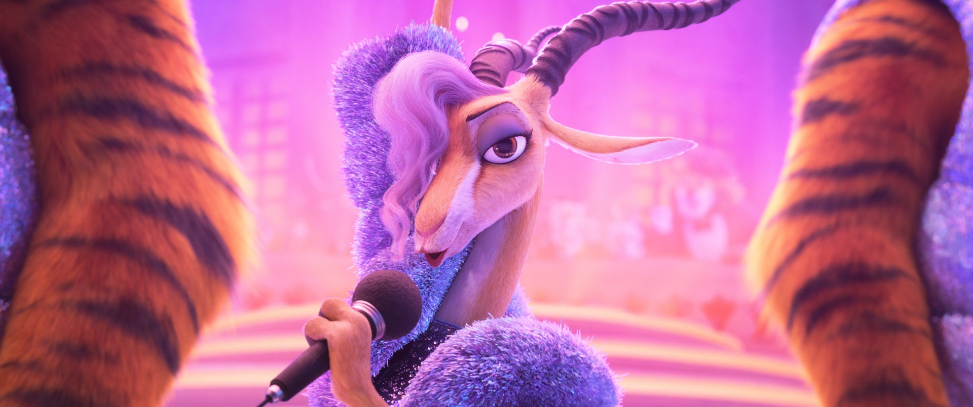 Animated gazelle character in a sparkling blue outfit holding a microphone, performing on stage with purple lighting and blurred audience in the background.