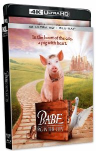 4K Blu-ray cover of "Babe: Pig in the City" featuring a pig sitting on a suitcase, with a duck and a dog nearby and a city skyline in the background.