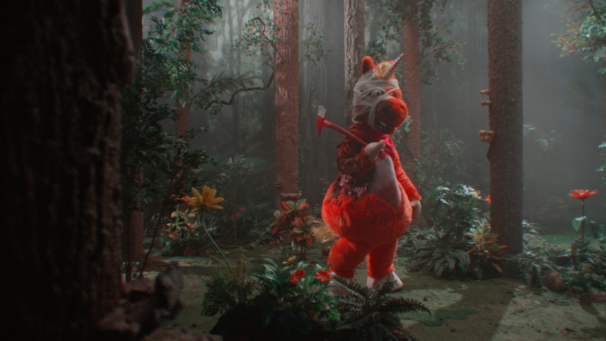 A person in a red and white animal costume stands in a dense, misty forest holding an axe over their shoulder.