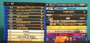 A collection of Blu-ray and Ultra HD movie cases stacked in two columns, displaying various film and TV show titles against a turquoise background.