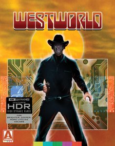 A humanoid robot in a cowboy outfit stands in front of a circuit board and sun backdrop; its faceplate is open, revealing mechanical components. "Westworld" title appears at the top.