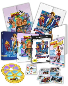 Box set of the film "BMX Bandits" with posters, DVDs, magazine cover, collectible cards, stickers, and colorful film reel coasters arranged on a black background.