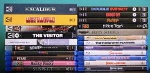 A collection of DVD and Blu-ray movie cases stacked in two columns, showing various film titles and their spines against a blue background.