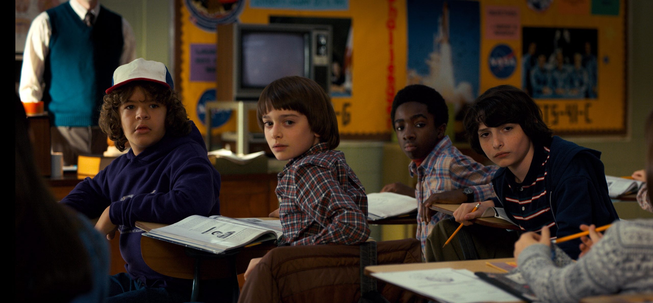 A young group of students sitting at desks in a classroom, engaged and attentive.