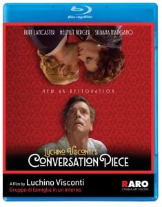 Blu-ray cover of "Luchino Visconti's Conversation Piece" featuring three characters, film title, cast names, and a red patterned background.