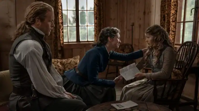 Three people sit in a wooden room; a woman in blue comforts a seated young woman holding papers, while a man with tied-back hair watches from a nearby chair.