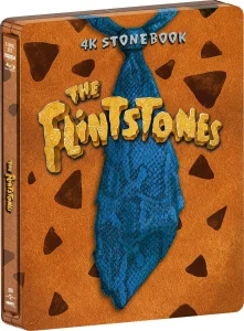 A Blu-ray box set titled "The Flintstones" with a blue patterned tie and a brown background featuring black spots. The text "4K Stonebook" is at the top.