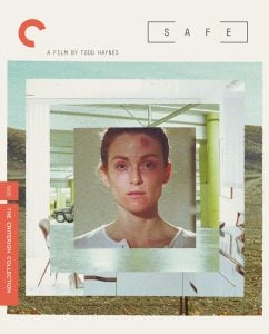A woman with a neutral expression is framed in the center, with modern architecture and a vintage car in the background. Text reads "Safe, A Film by Todd Haynes." Criterion Collection label on the side.