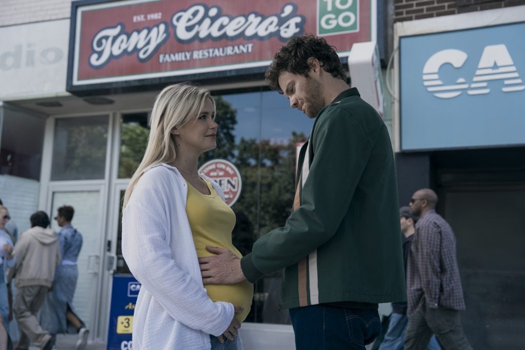 A man gently touches a pregnant woman's belly while they stand facing each other outside a restaurant called Tony Cicero’s.