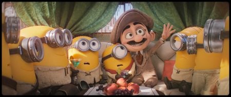 Universal To Release The Family Sequel ‘Minions & Monsters’ On 4K UHD Blu-Ray This September A group of four Minions sit on a couch with a man in a hat and suit, surrounded by fruit, with curtains in the background.