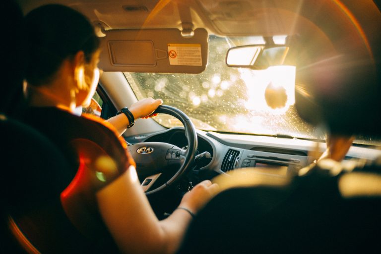 Kia Car Safety Technologies Every Driver Should Understand A person drives a car during sunset, with sunlight streaming through the windshield and illuminating the interior.