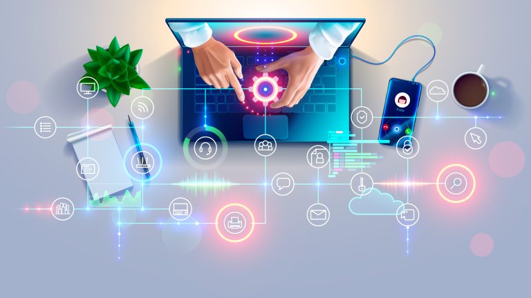 Top view of hands using a laptop surrounded by digital technology icons, a smartphone, notepad, plant, and a cup of coffee on a desk.