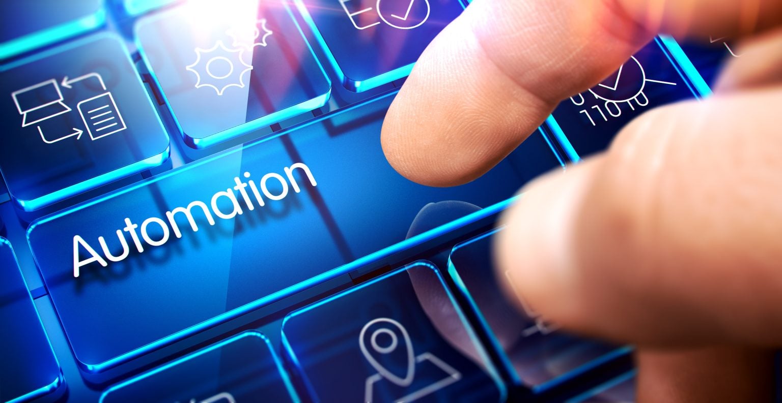 A finger pressing a glowing blue keyboard key labeled "Automation," surrounded by other illuminated keys with icons.