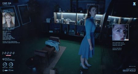A woman in a blue dress stands in a dimly lit room, viewed by a surveillance camera interface displaying identification and facial recognition data.