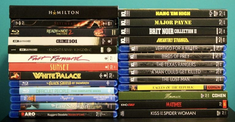 No Streaming Required: Physical Media Spotlight For The Week Of June 16th A collection of various Blu-ray and DVD movie cases stacked in two columns against a blue background.