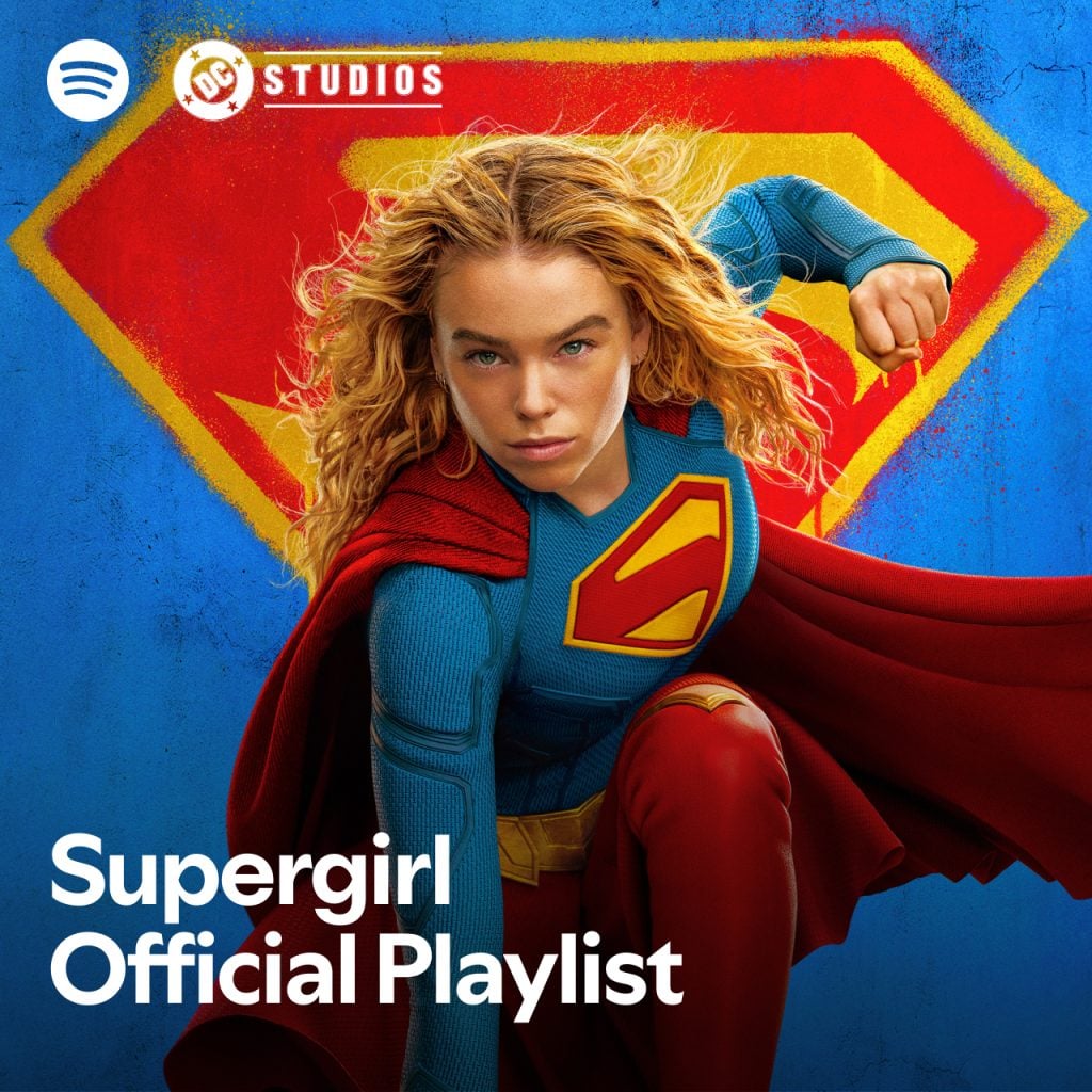 A woman in a Supergirl costume poses heroically in front of a large Supergirl “S” symbol. Text reads, "Supergirl Official Playlist," with Spotify and DC Studios logos visible.