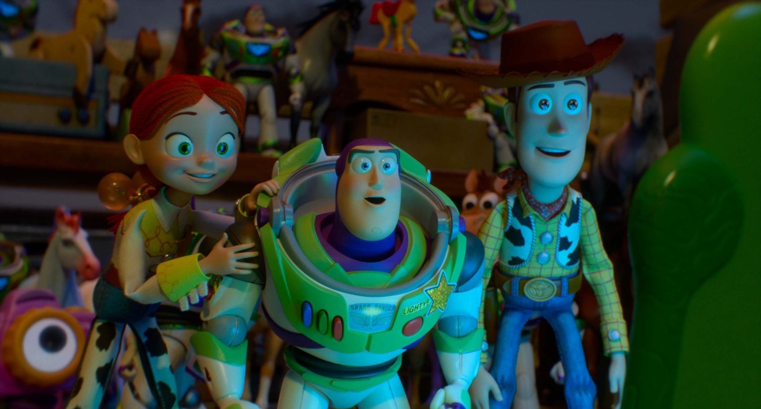 ‘Toy Story 5’ Review – Franchise’s Winning Streak Continues In This Somewhat Messy But Solid Entry Jessie, Buzz Lightyear, and Woody stand side by side, surrounded by other toys, looking forward with excited expressions.