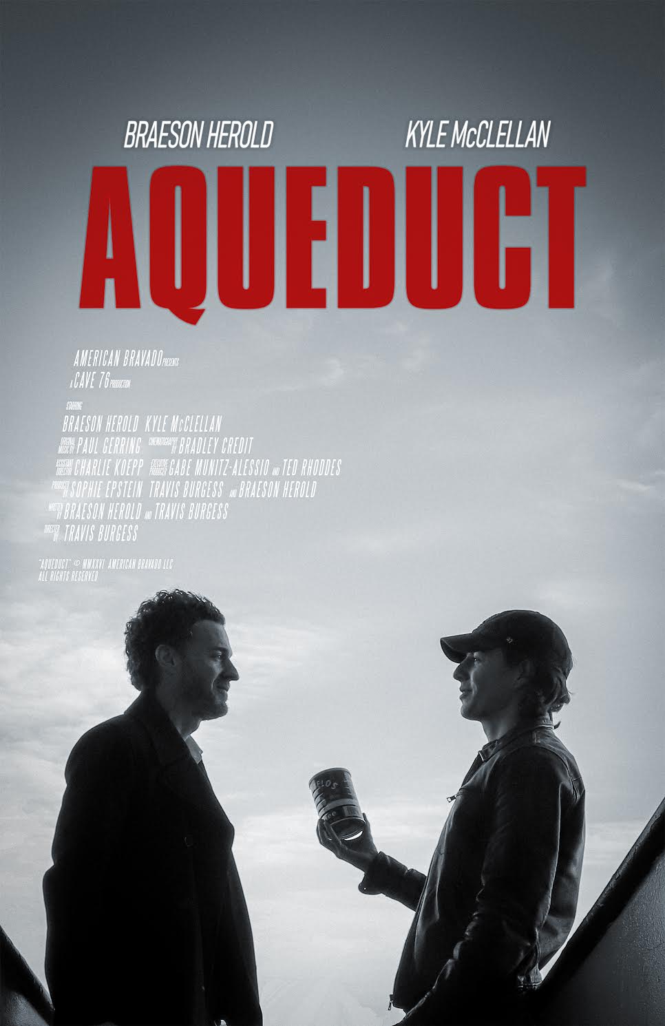 Two people stand talking outdoors under a cloudy sky, one holding a can, with the word "AQUEDUCT" in large red letters above them.