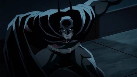 Warner Bros. To Release The First Installment of ‘Batman: Knightfall’ On 4K UHD Blu-Ray This September Animated Batman crouches in a defensive stance, cape spread wide, with a serious expression in a dark, shadowy environment.
