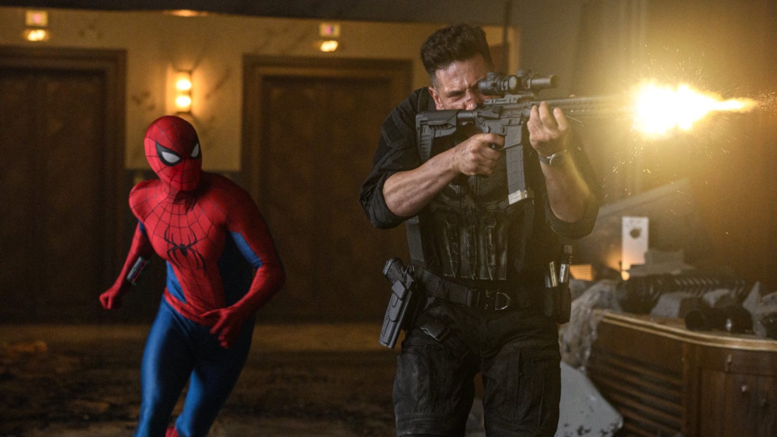 Spider-Man runs behind an armed man firing a rifle inside a dimly lit, damaged room with debris scattered on the floor.