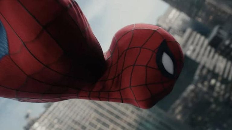Spider-Man in costume swings through a cityscape, with skyscrapers blurred in the background.