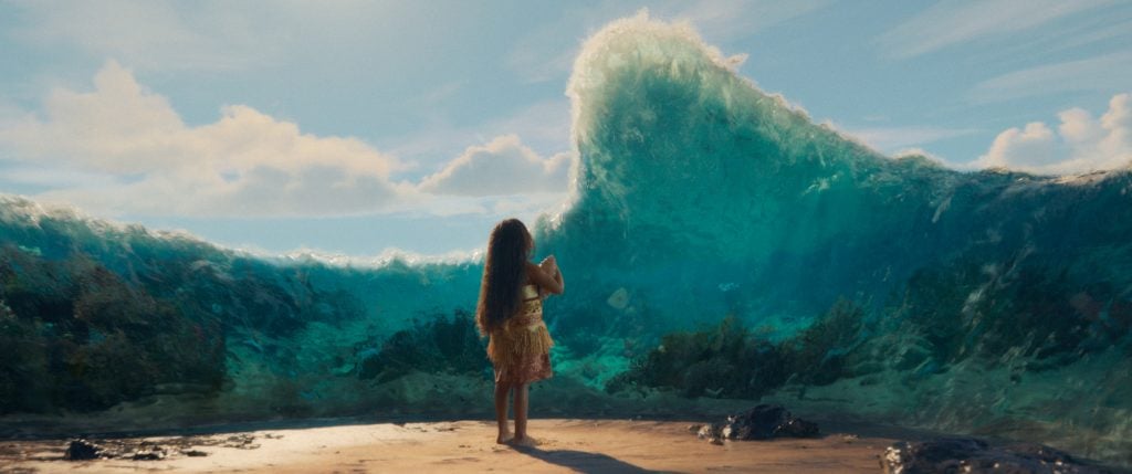 A girl stands on a beach facing a large wave that parts, revealing the ocean floor and marine life beneath clear blue water.
