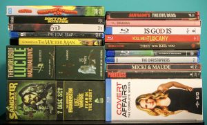 No Streaming Required: Physical Media Spotlight For The Week Of June 30th A collection of DVD and Blu-ray cases, including films, TV series, and box sets, arranged in two stacks on a flat surface.