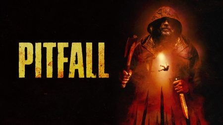 Richard Harmon And Alexandra Essoe Talk Wilderness Terror, Character Trauma, And Survival In ‘Pitfall’ A hooded figure holds an axe and knife with a person falling into a pit below; "PITFALL" is written in large yellow letters on the left.