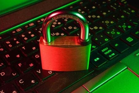 Preparing Today’s Cybersecurity Strategies for Tomorrow’s Threats A brass padlock sits on a black laptop keyboard with red and green lighting, suggesting digital security or data protection.