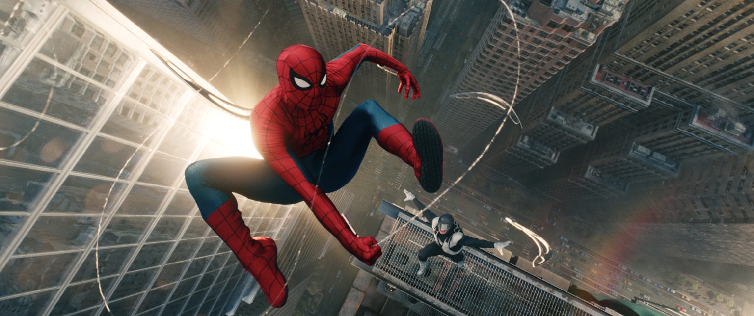 Spider-Man swings through a city with tall buildings, while another costumed figure follows behind, both high above the street below.
