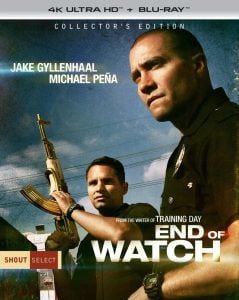Two uniformed police officers, one holding a rifle, stand alert under a blue sky on the “End of Watch” movie collector’s edition cover starring Jake Gyllenhaal and Michael Peña.