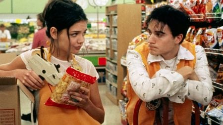 Arrow Video’s September Slate Include 4K UHD & Blu-Ray Releases From Kurt Russell, Michelle Pfeiffer & More Two grocery store workers in orange vests talk in an aisle; one holds a pricing gun and a bag of chips, the other leans on a shelf.