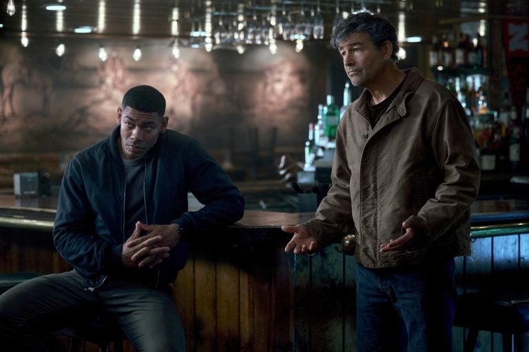 What’s New On HBO Max In August 2026: Lanterns, Mother Mary, Conan O’Brien And More Two men stand in a dimly lit bar; one leans against the counter with hands clasped, while the other gestures with open hands, both appearing serious.