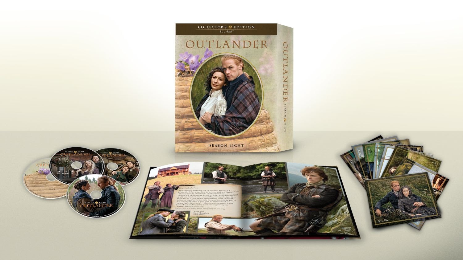 Outlander Season Eight collector’s edition set with box, two Blu-ray discs, booklet with photos, and a set of character cards displayed on a light surface.