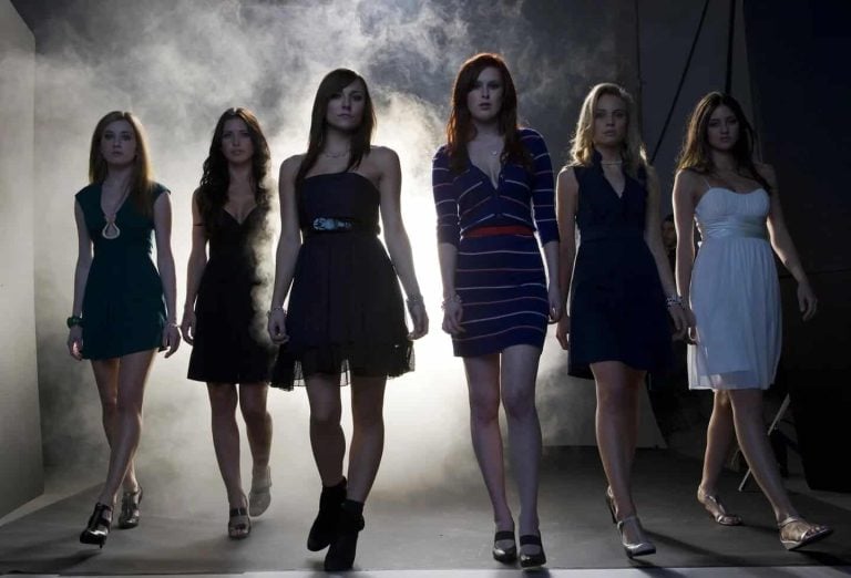 Lionsgate To Release The Horror Remake ‘Sorority Row’ On 4K UHD Blu-Ray This September Six young women walk confidently toward the camera in a smoky, dimly lit room, all wearing dresses and heels.