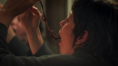 ‘Son Of Sara’ Review – For The Hell Of It A person pulls a long, dark object from their mouth while looking in a mirror.