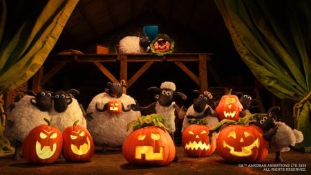 Animated sheep stand in a barn surrounded by carved, glowing jack-o’-lanterns with various facial expressions, indicating a Halloween celebration.