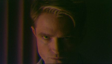 ‘Primetime’ Review – Lance Oppenheim And Robert Pattinson Spotlight The Hubris Of ‘To Catch A Predator’ A person with short, light-streaked hair stares intensely at the camera in low, moody lighting, with their face partially in shadow.