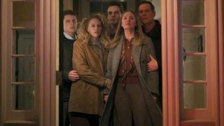 ‘Line of Fire’ Season 1 Review: Your Typical Network Drama With An Engaging Mystery Five people stand closely together in a doorway, looking outward with serious expressions. The group includes three young adults and two older adults, all wearing coats or jackets.