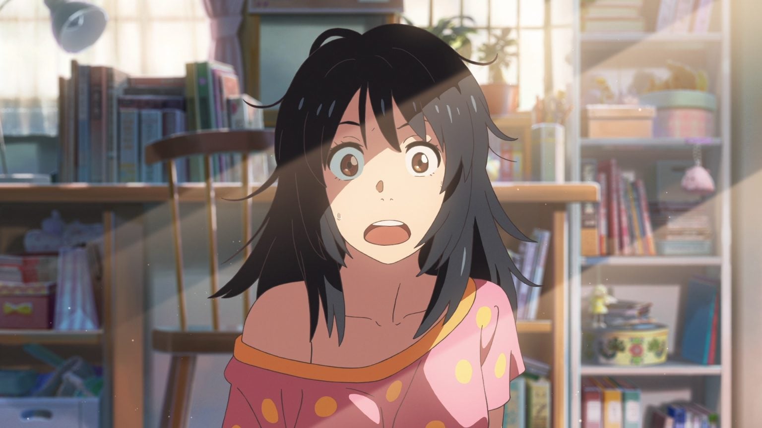 Anime girl with messy black hair and wide eyes sits in a sunlit room, wearing a pink shirt with orange spots; bookshelves and various items are visible in the background.
