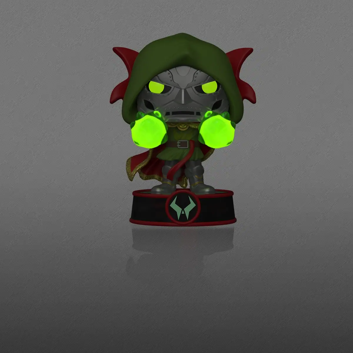 Doctor Doom Funko Pop figure wearing a green hood and cape, holding glowing green energy in both hands while standing on a circular base.