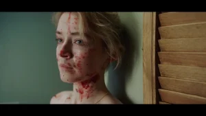 A woman with blood on her face and neck looking to the side.