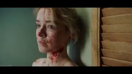 A woman with blood on her face and neck looking to the side.