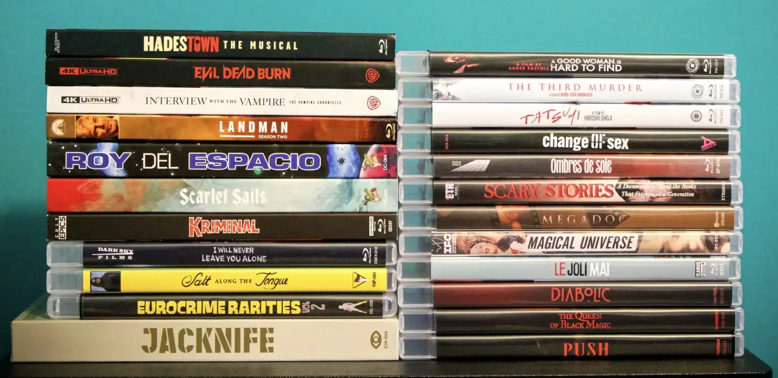 Two stacks of Blu-ray and 4K film cases arranged on a surface against a blue background.