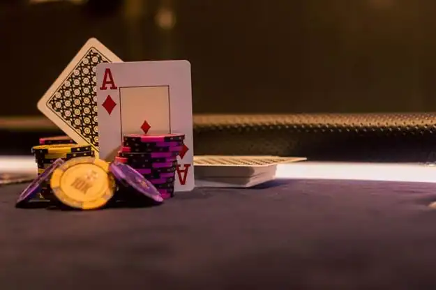 How To Check RNG Certification Before Playing Slots At A Gaming Site An ace of diamonds playing card leaning against a stack of purple poker chips next to a pile of yellow chips on a dark table.