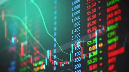 Slot Studios Go Public, And The Stock Market Learns To Price The Reels A digital stock market display showing red and green candlestick charts with a list of ticker symbols and numerical values.