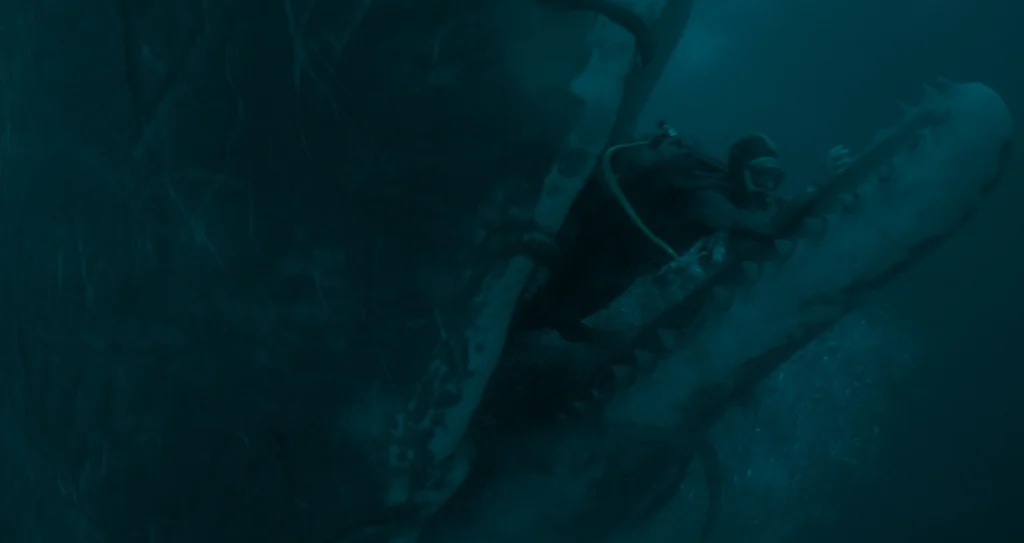 A diver swimming inside the open, tooth-filled mouth of a giant shark.